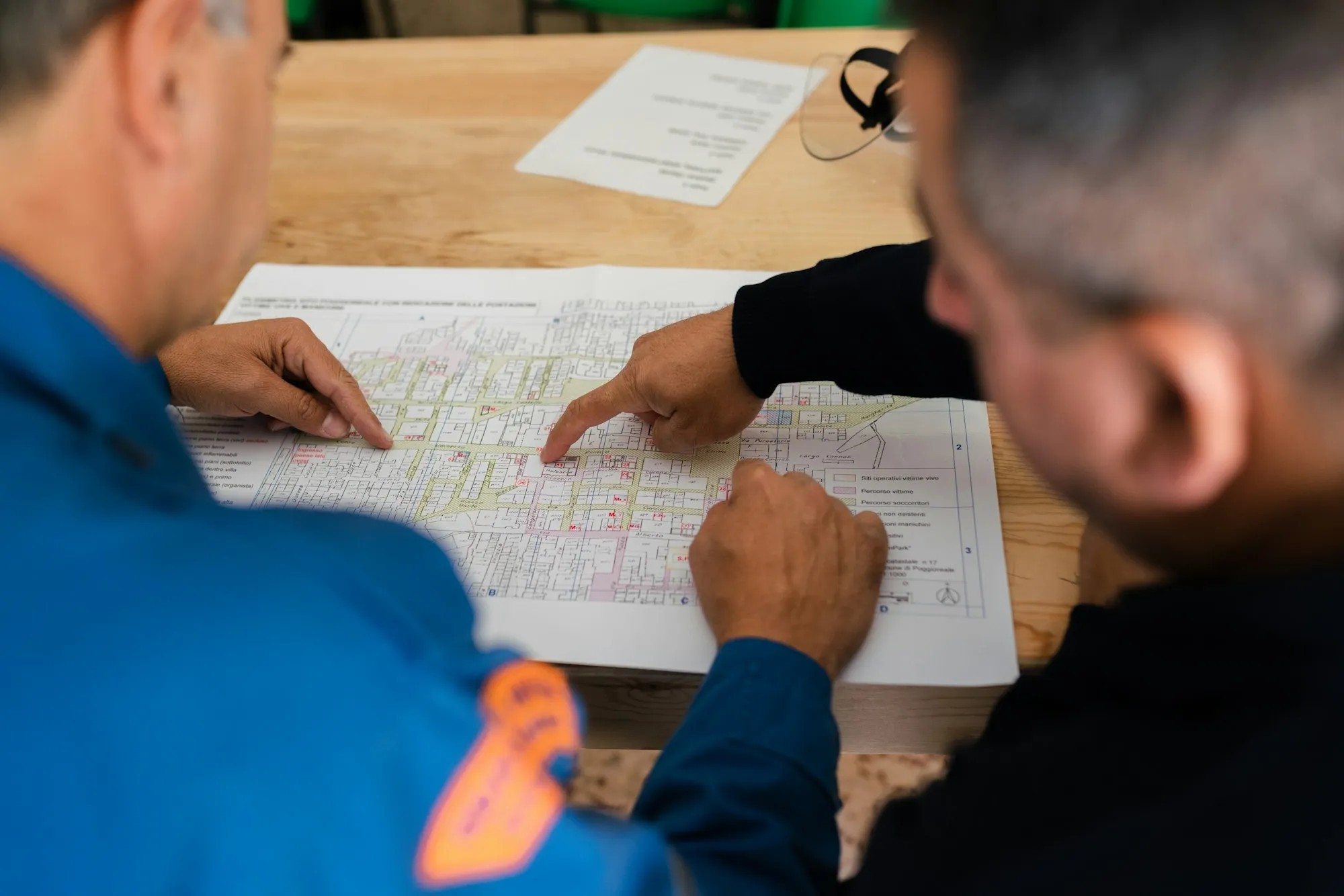Dos profesionales revisan planos técnicos sobre una mesa de trabajo.